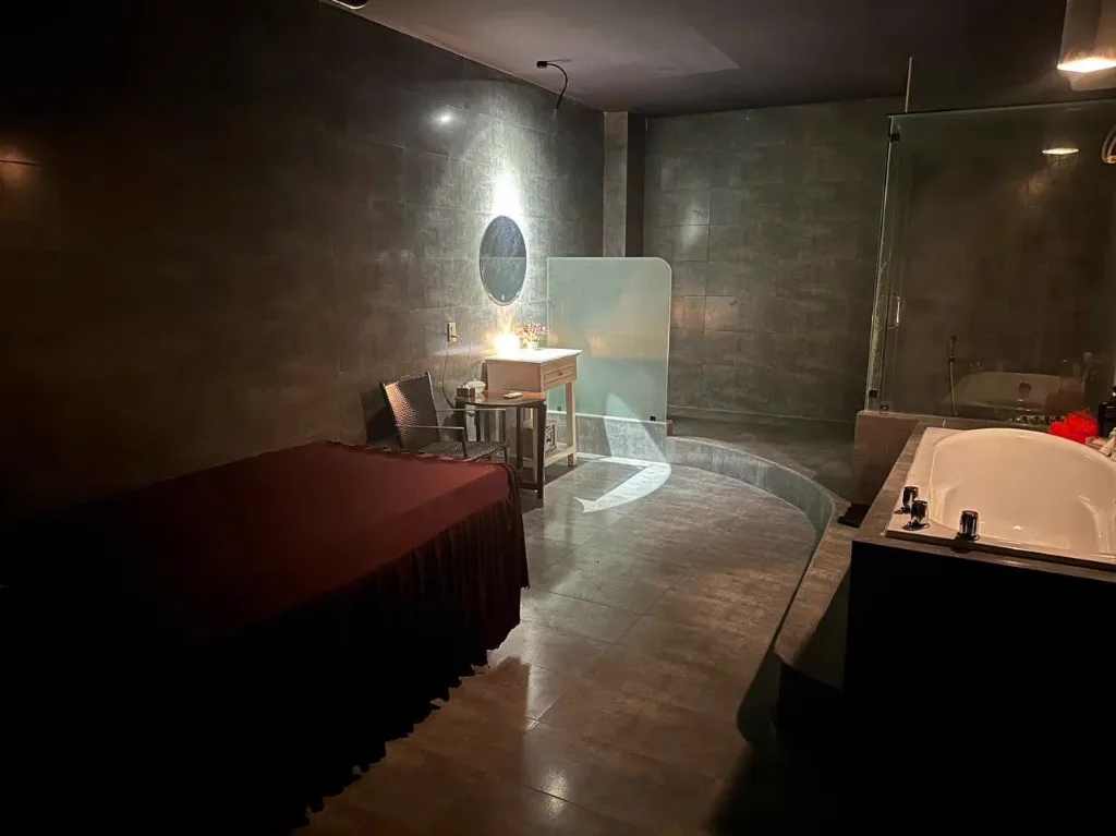 나트랑 화다2 마사지 1인실 욕조 옆 꽃 장식 화장대와 베드
