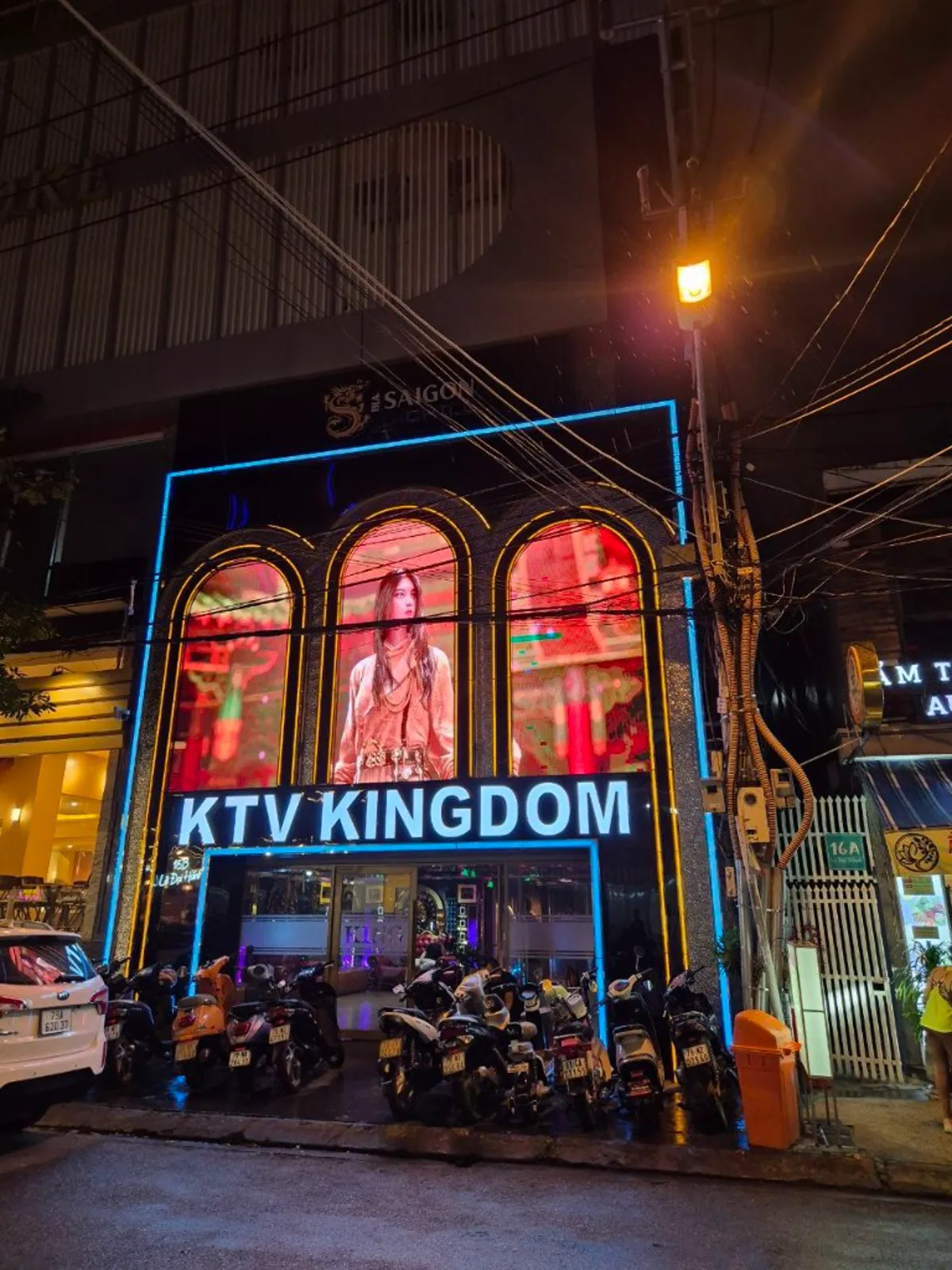 나트랑 킹덤 가라오케 골목 입구와 오토바이가 늘어선 야간 외관