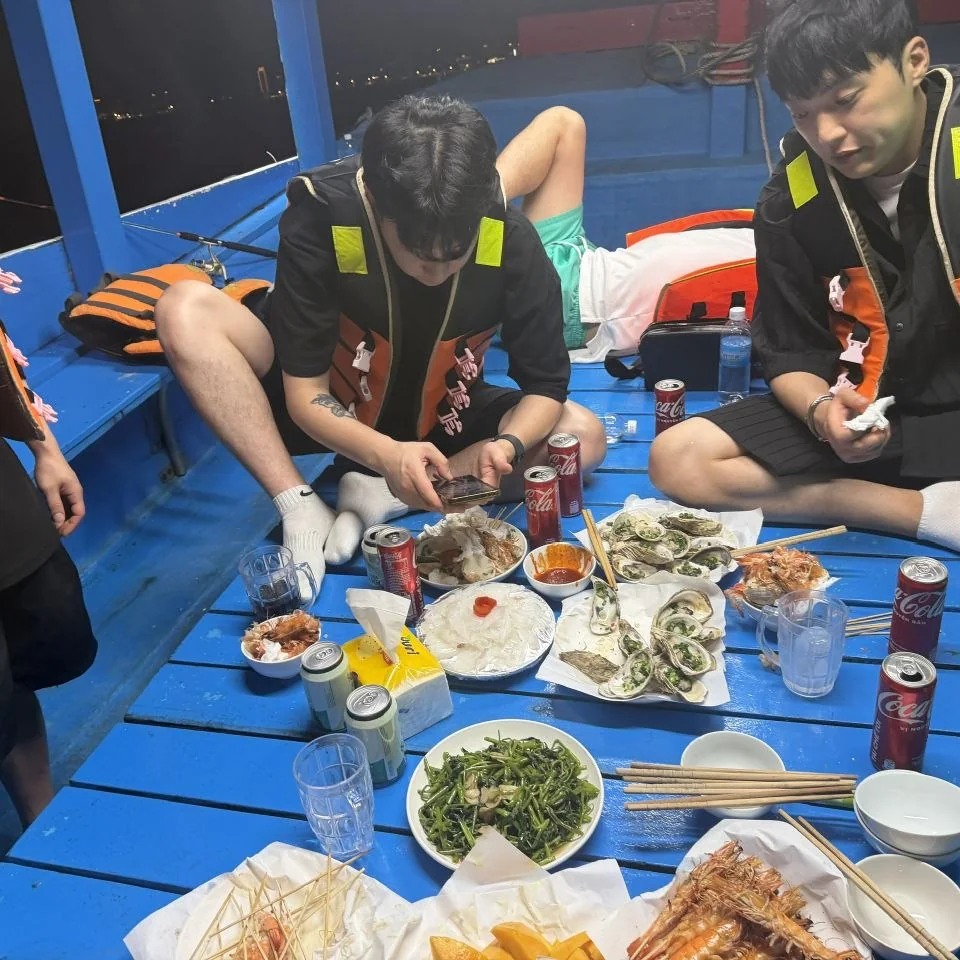 나트랑 오징어 낚시 투어 선상 해산물 BBQ 한 상 — 파란 테이블에 차린 해산물과 맥주